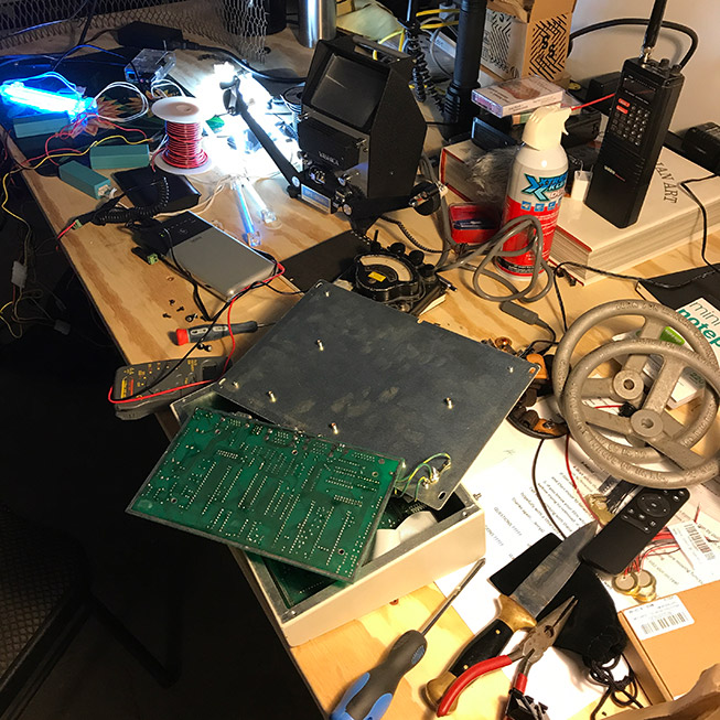 Overhead view of the work table with electronics projects on it