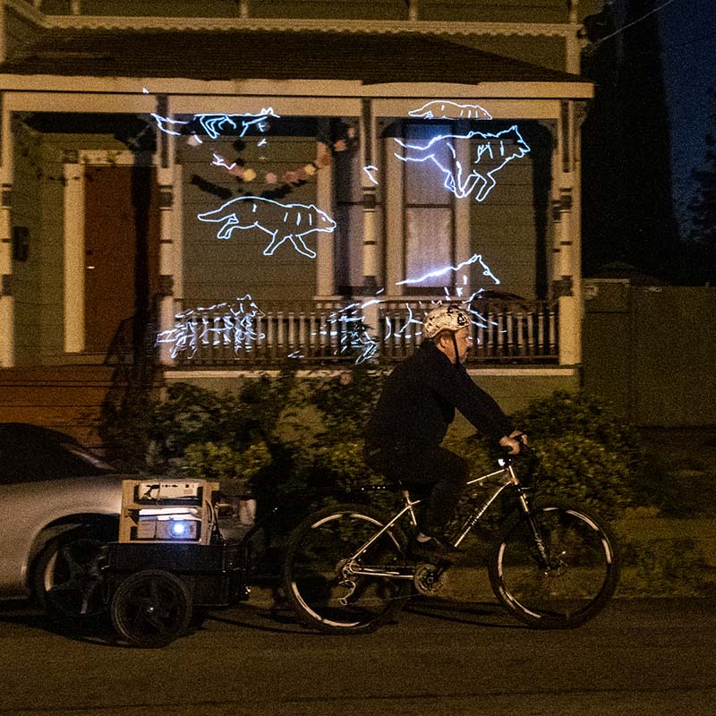 man riding bicycle with video projectors