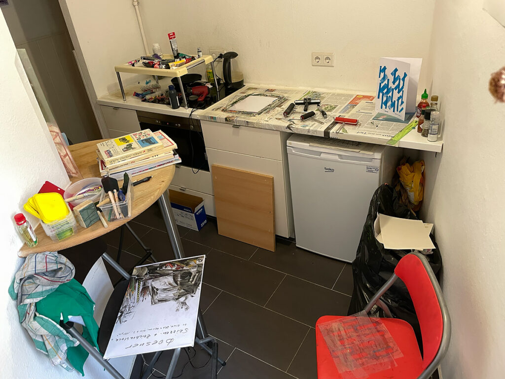 An overhead view of a kitchen filled with printmaking equipment